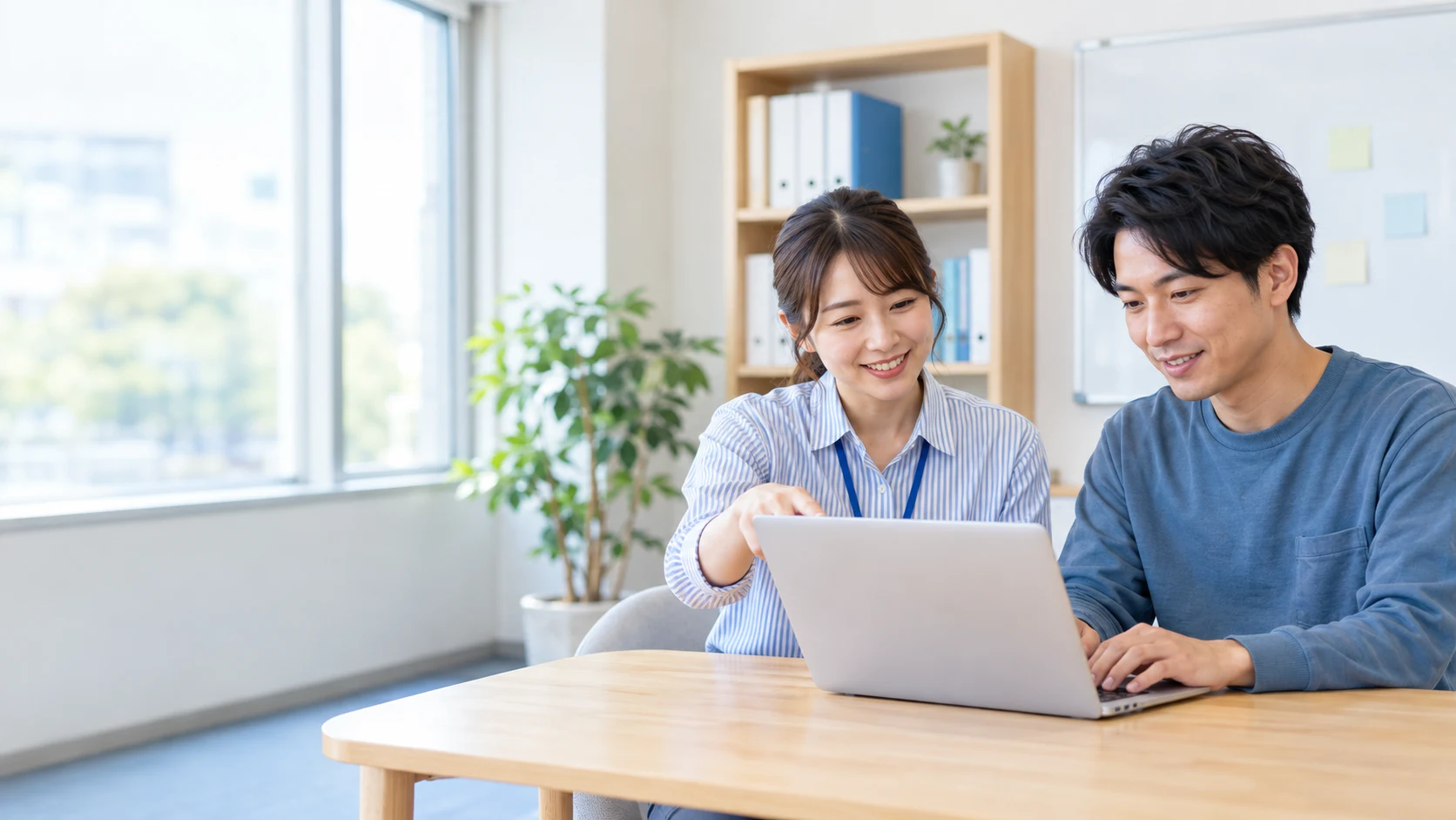 支援者と利用者が隣に座り、パソコンの画面を確認しているイメージ